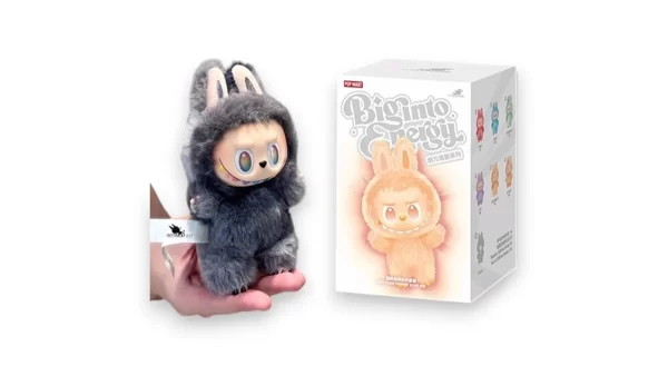 Figurka Labubu V3 big into energy v šedém plyšovém oblečku s oušky vedle originální krabičky Pop Mart – edice Big into Energy